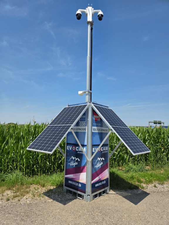 Mobiles Videoüberwachungssystem von Evocam mit Solarpanels und Kameras auf einem hohen Mast an einem Feldweg.